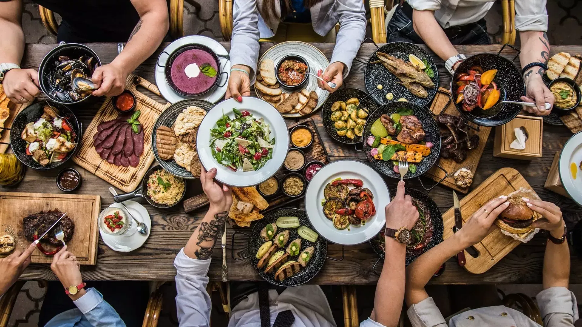 Personas sentadas en una mesa de comedor, compartiendo comida.