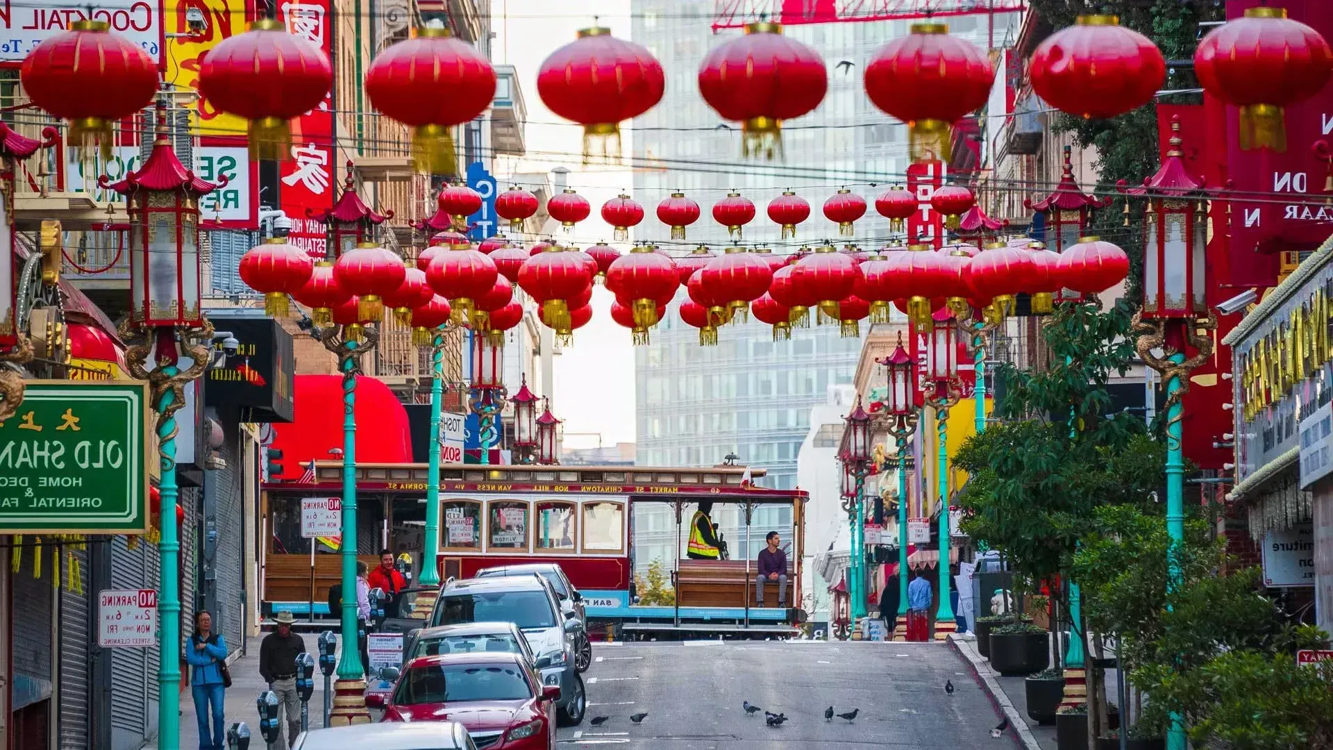 贝博体彩app唐人街连绵起伏的街道上悬挂着红色的灯笼，一辆有轨电车正在驶过。.