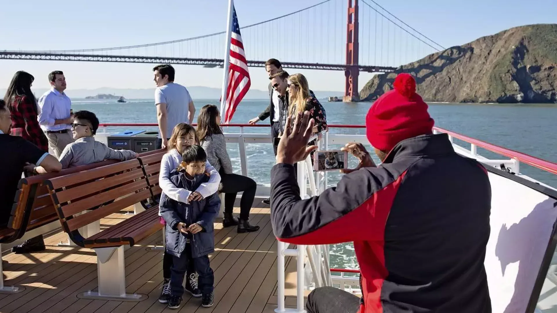 Una familia disfruta de un crucero por la bahía, pasando por el puente Golden Gate.