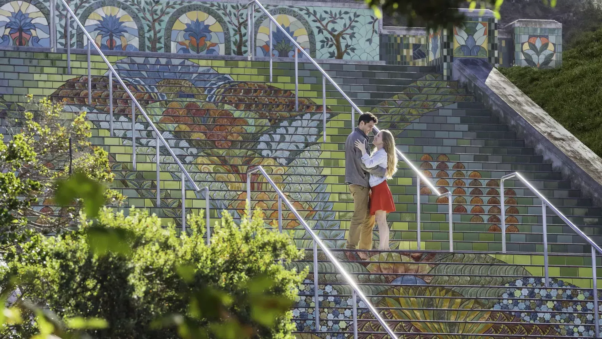 リンカーンパークのカラフルなタイル張りの階段に立っているカップルを斜めから撮った写真