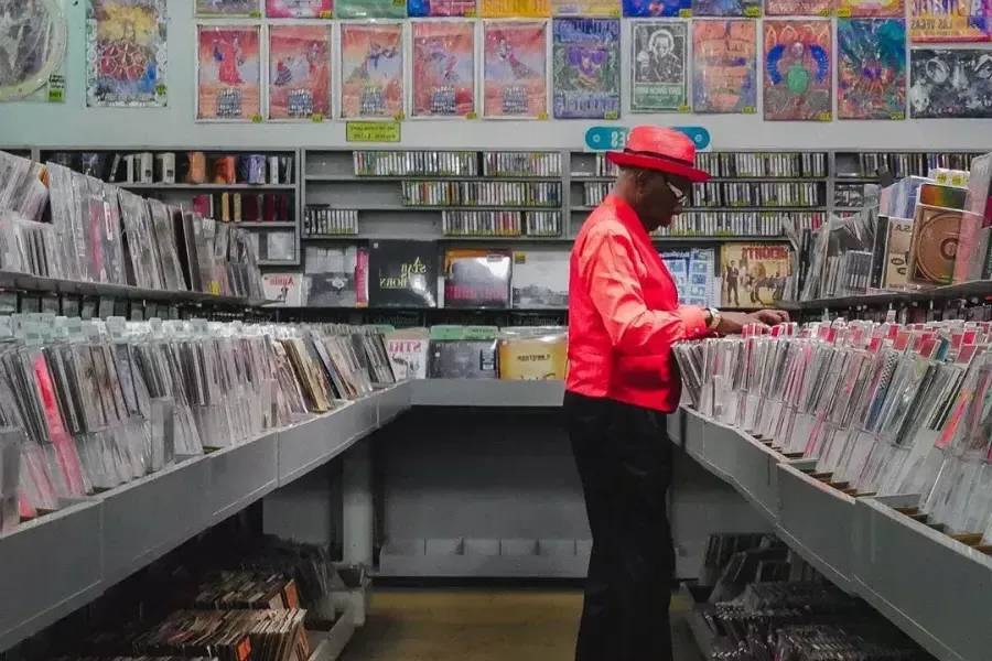 빨간 재킷을 입은 남자가 샌프란시스코의 아메바 레코드에서 음반을 구매하고 있습니다.