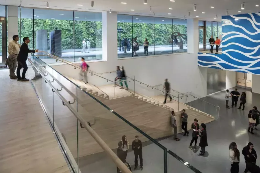 Le persone camminano su e giù per le scale in un arioso atrio del Museo di Arte Moderna di San Francisco (SFMOMA).